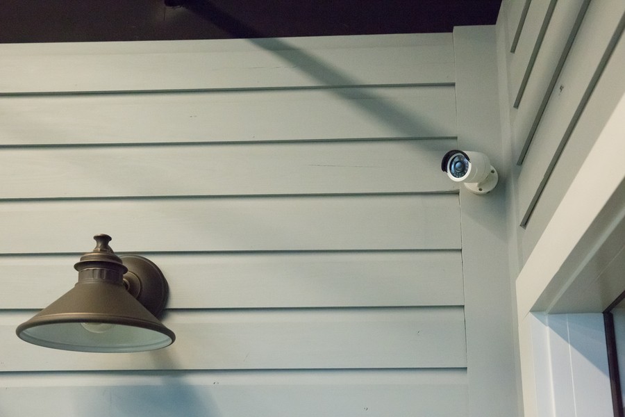 A home surveillance camera mounted on the outside of a house. 